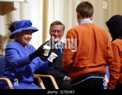 La Regina Elisabetta II della Gran Bretagna riceve due tazze dagli alunni durante la sua visita alla Lambeth Academy a Clapham, nel sud di Londra, che è stata ufficialmente aperta dalla Regina oggi. Il governo vuole che 200 accademie siano aperte o in costruzione entro il 2010, nel tentativo di trasformare le scuole secondarie in fallimento. Foto Stock