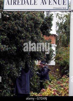 I poliziotti cercano i cespugli nei giardini all'interno di un'area cordonata fuori di una casa in Airedale Avenue, Chiswick, dove un uomo è stato pugnalato a morte quando ha catturato un ladro che ha rubato la sua casa. Foto Stock