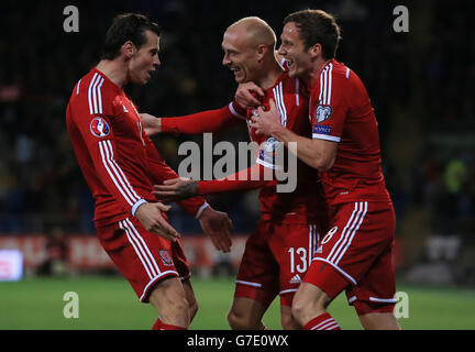 David Cotterill del Galles festeggia il gol di apertura con Gareth Bale (a sinistra) e Andy King (a destra) nel corso della vittoria 2.1 su Cipro , durante la partita di qualificazione UEFA Euro 2016 al Cardiff City Stadium di Cardiff. Foto Stock