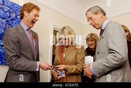 Il Principe di Galles (a destra) condivide una battuta con la signora Camilla Parker-Bowles (al centro), in quanto il Dr Tim Robinson (a sinistra) tiene una replica serpente, presso il centro integrato di assistenza sanitaria a Poundbury, Dorset. Robinson, che pratica la medicina omeopatica nel villaggio di punta del Principe, spiegava la capacità del veleno serpente di alleviare la PMT. Foto Stock