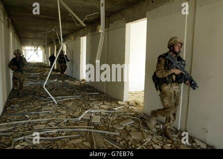 SOLO PER USO ALL'ESTERO: I soldati del gruppo di battaglia Black Watch, tra cui i Royal Marines del 40 Commando, hanno pulito gli edifici in un'ex tenuta industriale mentre erano in pattuglia. I soldati e i marinai sono stati dispiegati attraverso i veicoli blindati Warrior dalla loro vicina base operativa 'Pringfield', che si trova vicino alla riva orientale del fiume Eufrate, 25 miglia a sud di Baghdad. Foto Stock