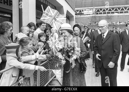 La regina Elisabetta II riceve fiori da giovani ammiratori durante una visita al centro commerciale King Edward Court di Windsor. Foto Stock