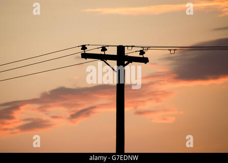 Fotografia di un palo elettrico e un cielo nuvoloso al tramonto Foto Stock
