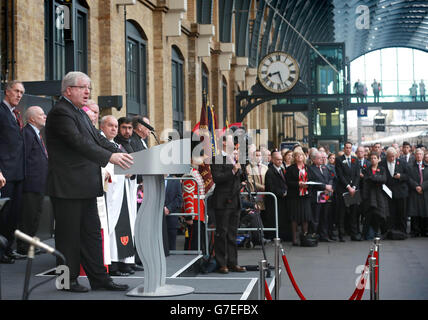 Il Segretario ai Trasporti Patrick McLoughlin si rivolge al pubblico alla stazione di King's Cross a Londra durante un evento di ricordo con la locomotiva di Classe 91 della East Coast, specialmente in livrea, "for the Fallen" (numero 91111). Foto Stock