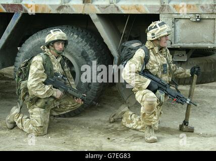 I soldati della 'A' Company of the Black Watch si preparano a cercare tra le case quando l'alba si rompe durante un'operazione sulla riva orientale del fiume Eufrate, Iraq, che ha preso di mira un sospetto surrogato letto chiamato 'Millionaires' Row'. Nella più grande offensiva da quando è stata riutilizzata in Iraq centrale, un totale di 80 sospetti sono stati arrestati, ma molti sono stati rilasciati in seguito. Circa 20 persone sono state trattenute per ulteriori interrogativi. Le forze britanniche trovarono anche attrezzature sospette per la produzione di bombe. Foto Stock