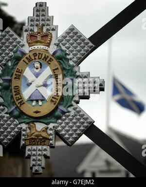 La bandiera di Saltyre si flys a metà albero dietro il badge regimental Black Watch fuori dei cancelli del quartier generale regimentale Black Watch Royal Highland presso il castello di Balhousie a Perth. Tre membri del Black Watch sono stati uccisi ieri in Iraq da un attentatore suicida ad un checkpoint per veicoli il secondo giorno del loro controverso schieramento per sostenere le truppe statunitensi a sud di Baghdad. Foto Stock