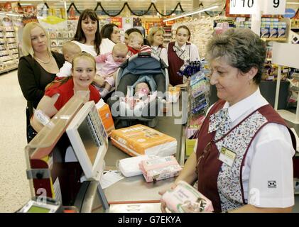 Sette donne che sono cadute incinte in mesi l'una dall'altra lavorando nel supermercato Morrisons, Failsworth, Manchester - sei di loro sulla stessa cassa, essendo serviti i fazzoletti e pannolini del bambino. Le madri, (da sinistra a destra) sono Tereza Denniston che ha lavorato nel caffè con Samantha di tre mesi sul nastro trasportatore, Trudi Eladihab con Laith di 19 settimane, Carol Jamieson con Jessica-May di quattro mesi, Penny Boardman, Tina Priest, Claire Walker e Lauren Baldwin che hanno lavorato fino al numero 10. Un'ottava donna, Sinead Ginty (non raffigurata), lavorò anche fino al numero 10 e partorì a maggio. Foto Stock