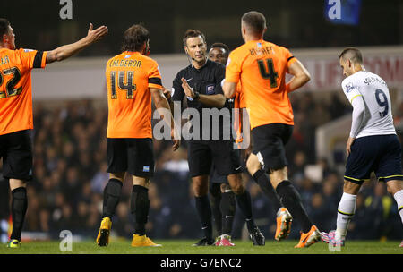 Calcio - Capital One Cup - Fourth Round - Tottenham Hotspur v Brighton & Hove Albion - White Hart Lane. L'arbitro Mark Clattenburg (al centro) sostiene con Brighton & Hove Albion's Inigo Calderon (a sinistra) Foto Stock