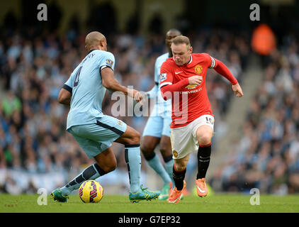 Wayne Rooney di Manchester United affronta la palla con Vincent Kompany di Manchester City (a sinistra) durante la partita della Barclays Premier League all'Etihad Stadium di Manchester. PREMERE ASSOCIAZIONE foto. Data immagine: Domenica 2 novembre 2014. Guarda la storia di calcio della PA Man City. Il credito fotografico dovrebbe essere Martin Rickett/PA Wire. . . Foto Stock