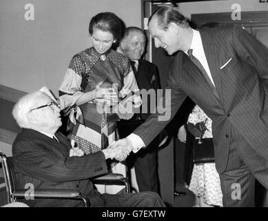 Il duca di Edimburgo scuote la mano di Sir Charles Chaplin, mentre la regina guarda sopra. Ha aperto ufficialmente l'International Centre, nuova sede dell'accademia britannica del cinema e della televisione a Piccadilly, Londra. *scansione a bassa risoluzione da stampa, alta risoluzione disponibile su richiesta* Foto Stock