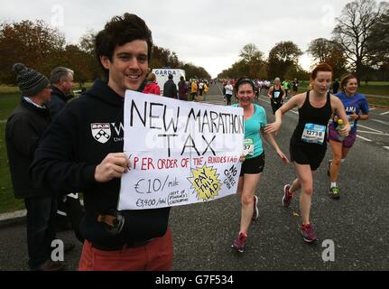 FOTO. Oisin Kenny tenta di applicare una tassa sulla maratona mentre i corridori si fanno strada attraverso Phoenix Park, mentre più di 14,000 persone hanno preso parte alla 35a maratona della città di Dublino, Irlanda. Foto Stock