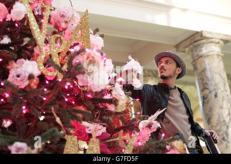 Lo stilista Matthew Williamson lancia il suo albero di Natale creato appositamente per il V&A's Grand Entrance a Cromwell Road, Londra. Oltre 1000 rose rosa di velluto e chiffon decorano l'albero alto sei metri. Foto Stock