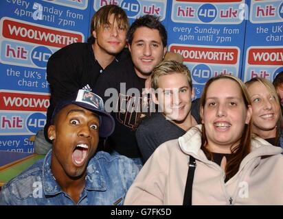 (Da sinistra a destra) Simon Webbe, Duncan James, Antony Costa e Lee Ryan della boy band Blue posano con i fan, durante l'apparizione presso il negozio Woolworths Big W a Small Heath, Birmingham, per promuovere il loro album "Best of Blue". Foto Stock