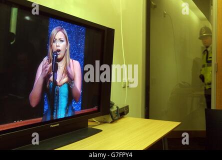 Un agente di polizia guarda su un monitor televisivo della chiesa di Charlotte durante la sua performance al concerto di Royal Gala al Wales Millennium Centre. Foto Stock
