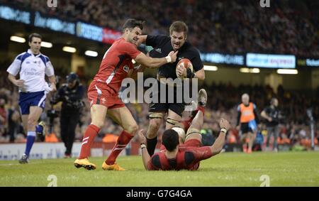 Il capitano della Nuova Zelanda, Richie McCaw (centro), tenta di eludere gli attacchi di Mike Phillips (a sinistra) e Taulupe Faletau durante la partita dove Men Series al Millennium Stadium di Cardiff. Foto Stock