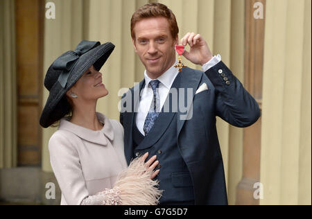 L'attore Damian Lewis con sua moglie Helen McCrory come ha tiene il suo ufficiale dell'Ordine dell'Impero britannico (OBE) dopo la cerimonia di investitura a Buckingham Palace nel centro di Londra. Foto Stock