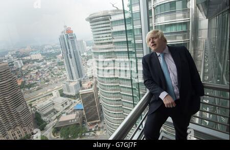 Il sindaco di Londra Boris Johnson sorge sul ponte che collega le Petronas Towers, uno degli edifici più alti del mondo, a Kuala Lumpur, Malesia. Foto Stock