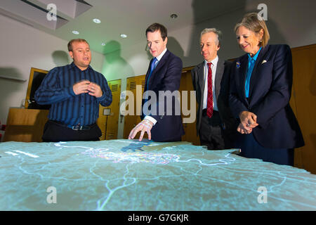 Docente in Big Data Analytics Steven Grey (a sinistra), dimostra la London Data Table che visualizza i dati analitici sulla capitale al Cancelliere dello scacchiere George Osborne, amministratore delegato della British Library Roly Keating e presidente della British Library Baroness Tessa Blackstone, Durante una visita per lanciare il Knowledge Quarter, presso la British Library, nel centro di Londra. Foto Stock