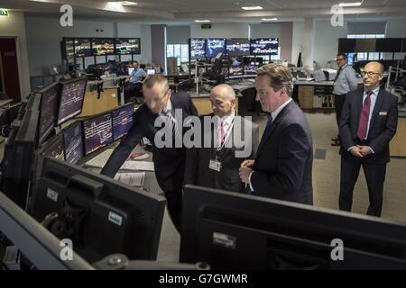 Il primo ministro David Cameron esamina i monitor per computer di segnalazione nella sala di segnalazione presso il Network Rail Operating Center di Cardiff, Galles. Foto Stock