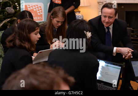 Il primo ministro David Cameron si unisce agli studenti di Downing Street per un'ora di codifica, in quanto annuncia che saranno formati 17,500 insegnanti di matematica e scienze, verrà aperto un nuovo college nazionale di competenze digitali e verrà introdotto un nuovo GCSE di informatica, incentrato sulla codifica. Foto Stock