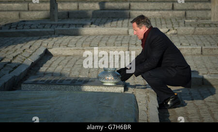 Il primo ministro David Cameron getta una candela presso il memoriale del campo di sterminio di Birkenau in Polonia, durante una visita personale che ha effettuato nei campi di concentramento di Auschwitz e Birkenau per la prima volta da quando è diventato primo ministro. Foto Stock