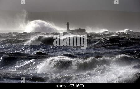 Onde giganti hanno colpito il muro del faro di Whitehaven, poiché le tempeste causano interruzioni in diverse parti del Regno Unito con interruzioni di corrente, cancellazioni di traghetti e treni e condizioni di guida difficili. Foto Stock