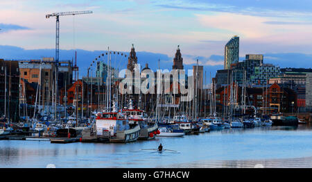 Un canoista si fila lungo l'acqua al Brunswick Dock, Liverpool, mentre la luce svanisce per il giorno. Foto Stock