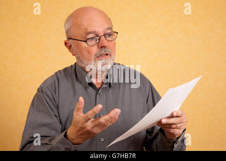 Uomo anziano, 59, tenendo una lettera, Bill, interrogando look, sconvolto l'espressione Foto Stock