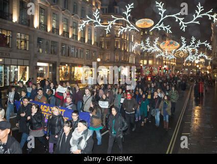 I manifestanti marciano attraverso Regent Street nel centro di Londra dopo aver dimostrato fuori dall'Ambasciata degli Stati Uniti, in seguito alla decisione di non perseguire l'ufficiale di polizia Darren Wilson per la morte del tiratore dell'adolescente nero Michael Brown a Ferguson, Missouri. Foto Stock