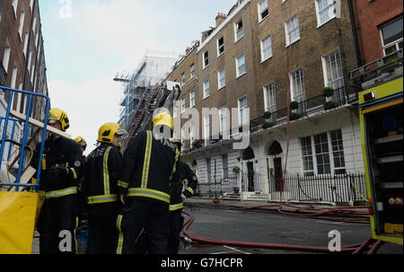 I vigili del fuoco frequentano la scena di un incendio a Wimpole Street, nel centro di Londra. Nove persone sono state evacuate dall'edificio dopo che la Brigata dei vigili del fuoco di Londra è stata chiamata all'incidente questa mattina. Foto Stock