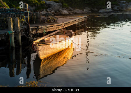 Il golden ora luce della sera cade su una barca a remi in Peggy's Cove, Nova Scotia, Canada. Foto Stock