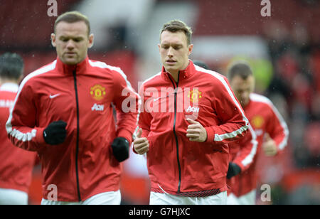 Phil Jones (a destra) del Manchester United si riscalda prima della partita contro Liverpool, prima della partita della Barclays Premier League a Old Trafford, Manchester. Foto Stock