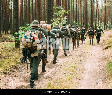 Unidentified Re-enactors vestito come il tedesco Wehrmacht soldato a piedi nella foresta di estate Foto Stock