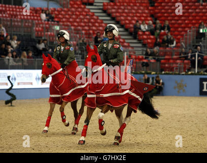 I membri del West Oxfordshire Riding Club si vestono come il RAF Red Arrows Display Team mentre competono nel SEIB/British Riding Clubs Quadrille dell'anno durante il sesto giorno dell'Olympia London International Horse Show presso l'Olympia Exhibition Center di Londra. Foto Stock