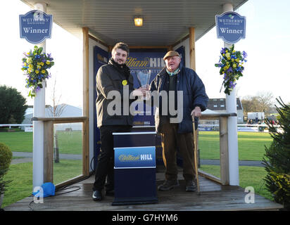 Mick Easterby (a destra) l'allenatore di Santi e peccatori riceve il suo trofeo dopo aver vinto il William Hill Exclusive Mobile Offers Novices' Limited handicap Steeple Chase il secondo giorno del William Hill Yorkshire Winter Festival all'ippodromo di Wetherby, Wetherby. PREMERE ASSOCIAZIONE foto. Data immagine: Sabato 27 dicembre 2014. Il credito fotografico dovrebbe essere: Anna Gowthorpe/PA Wire. Foto Stock