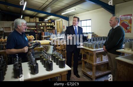 Il primo ministro David Cameron incontra il personale della St Eval Candle Company a Wadebridge in Cornovaglia, dove ha anche tentato di fare una candela versando cera calda in una muffa. Foto Stock