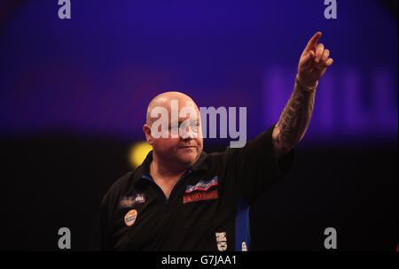 Andy Hamilton festeggia un 180 durante la sua partita contro Dave Richardson il campionato mondiale di freccette William Hill ad Alexandra Palace, Londra. Foto Stock