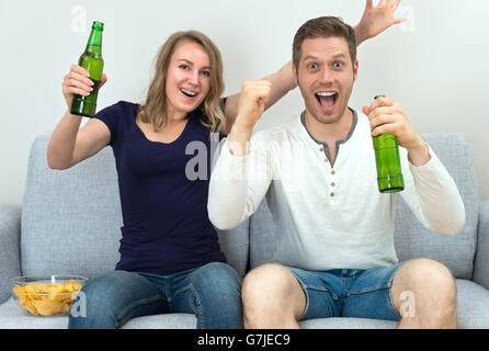 Eccitato giovane guardare sport match in tv. Foto Stock