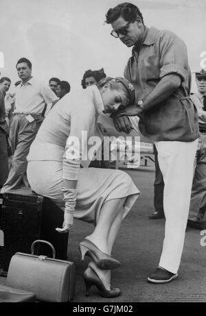 In mezzo al trambusto delle riprese, l'attrice svedese Anita Ekberg comincia a sentirsi stanca mentre appoggia la testa sul marito britannico dell'attore Anthony Steel. Si trova a Roma per la ripresa del suo nuovo film "Interpol". Foto Stock