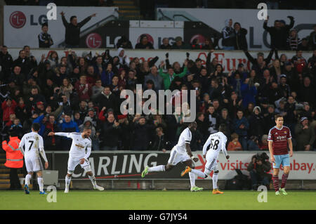 Il Bafetimbi Gomis di Swansea City festeggia dopo che Mark Noble ha segnato un gol durante la partita della Barclays Premier League al Liberty Stadium di Swansea. Foto Stock