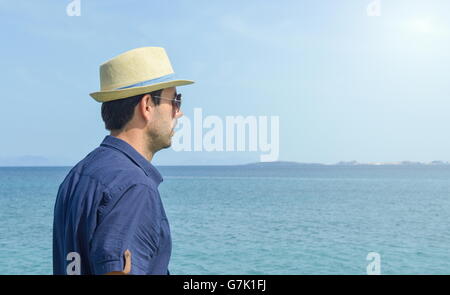 Uomo in camicia blu guardando l'orizzonte al mare Foto Stock