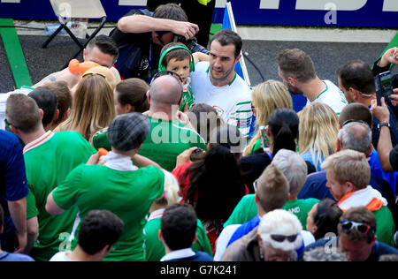 Repubblica di Irlanda John O'Shea tiene il suo figlio Alfie come egli va oltre ai fan dopo il turno del 16 corrispondono allo Stade de Lyon Lione. Foto Stock