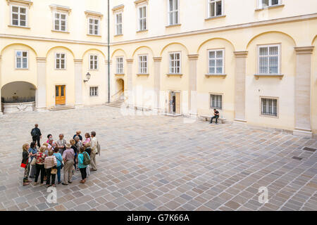 Gruppo di turisti con guida turistica in tribunale svizzero, il Palazzo Imperiale Hofburg di Vienna in Austria Foto Stock