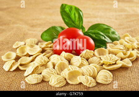 Orecchiette pomodori e basilico sulla iuta Foto Stock