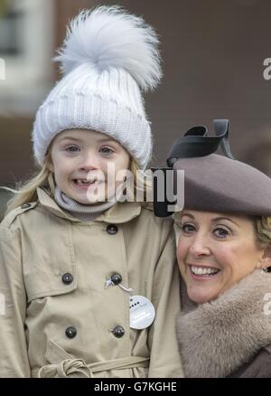 Chanelle McCoy, la moglie del campione jockey Tony McCoy, tiene sua figlia Eve mentre guardano la sfilata prima della corsa di ostacoli Betfred Mobile HeroesHandicap durante il Betfred Masters Day all'ippodromo di Sandown Park, Surrey. Foto Stock