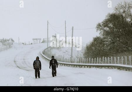 Andrew Millington (a sinistra) e Stephen Peacock camminano vicino allo Spittal di Glenshee, mentre la neve porta nuove perturbazioni in alcune parti del Regno Unito. Foto Stock