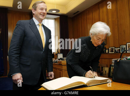 Una Taoiseach Enda Kenny con l'Amministratore Delegato del Fondo monetario Internazionale Christine Lagarde mentre firma il libro dei visitatori al suo arrivo negli edifici governativi mentre si trova a Dublino per una conferenza speciale per rivedere l'esperienza irlandese del salvataggio internazionale. Foto Stock