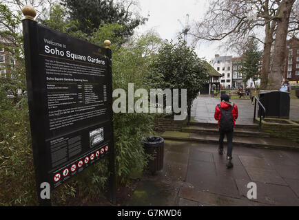 Un uomo cammina attraverso i Soho Square Gardens a Soho, nel centro di Londra. Foto Stock