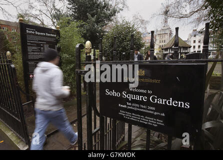 Soho stock - Londra. Un uomo cammina attraverso le porte dei Soho Square Gardens a Soho, nel centro di Londra. Foto Stock