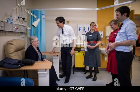 Il leader del lavoro ed Miliband (seconda a sinistra) e il segretario ombra Andy Burnham (destra) incontrano il personale e i pazienti nell'unità di cure ambulatorie e nell'unità di medicina acuta durante una visita all'ospedale George Eliot di Nuneaton. Foto Stock